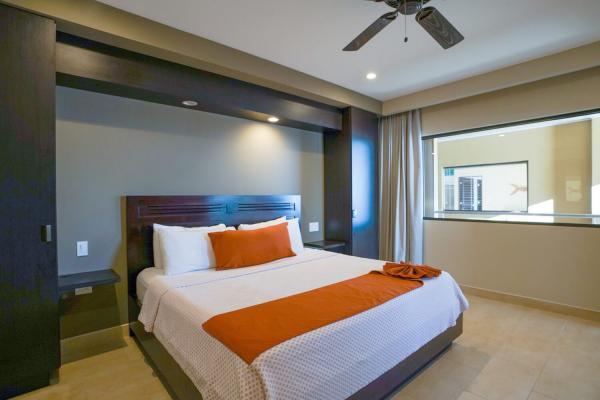 King room with orange runner and pillow at Hotel Cocal, window facing outdoor walkway