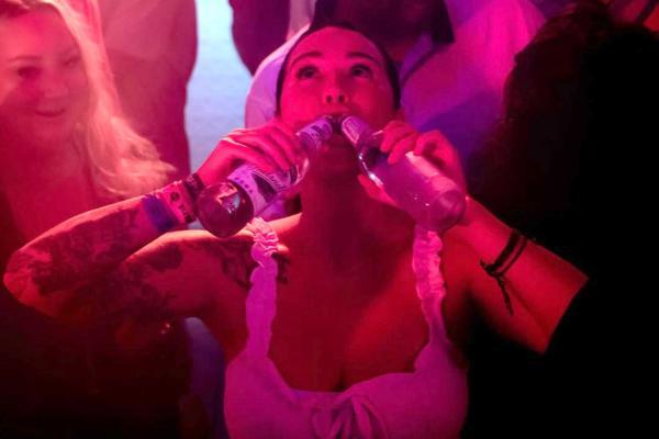 Hot girl at Orange Pub in Jaco Nightlife scene with drinking two bottles