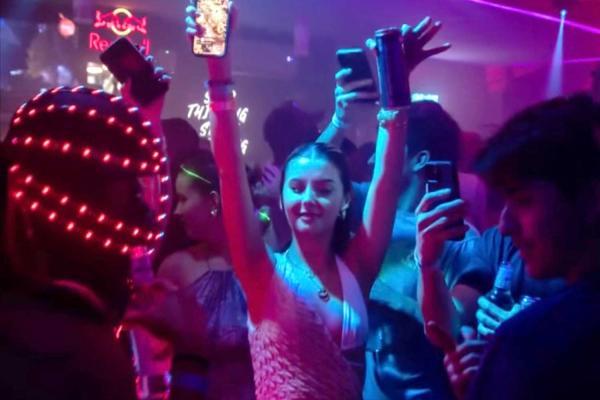 Party crowd and go-go dancers at Orange Pub in Jaco Beach nightlife scene