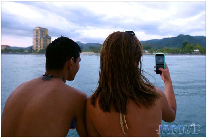 guy and girl on boat taking picture of jaco beach in the background