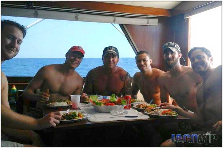 Group of guys eating lunch in boat salon