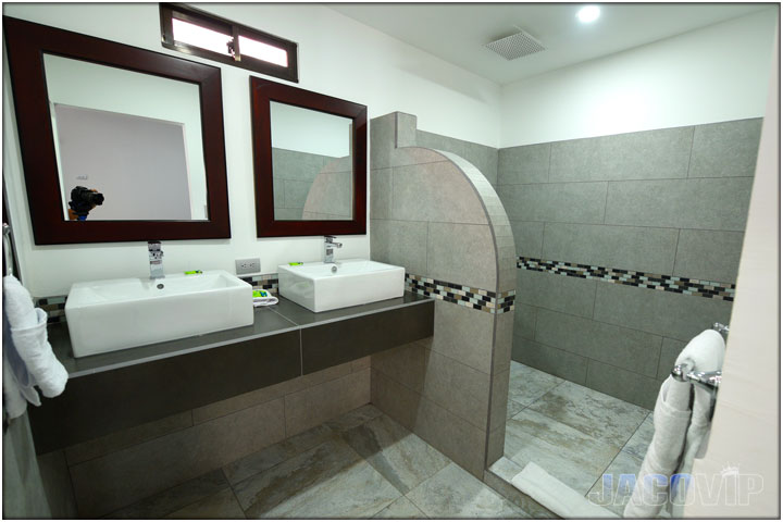 Bathroom with 2 sinks and rounded shower seperation