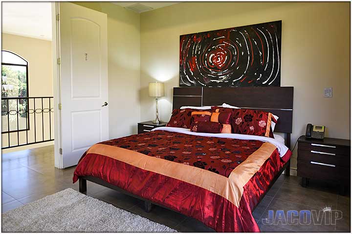 King size bed with red bed duvet and matching wall art