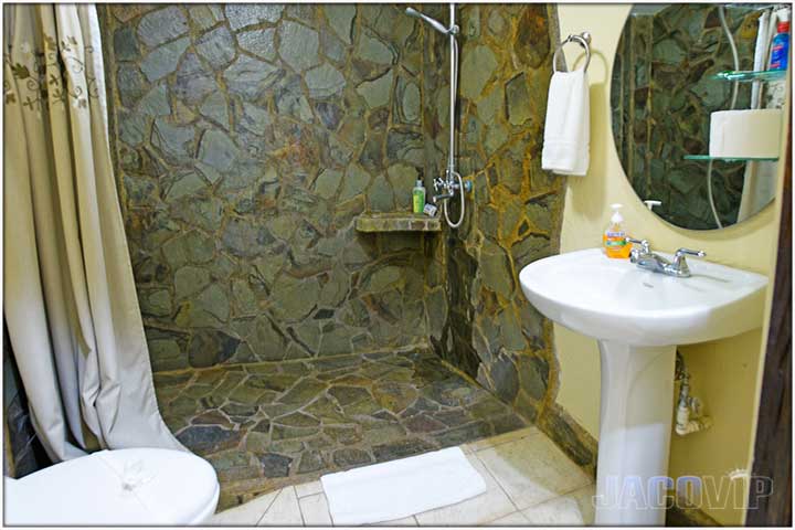 Bathroom with rocky tile wall