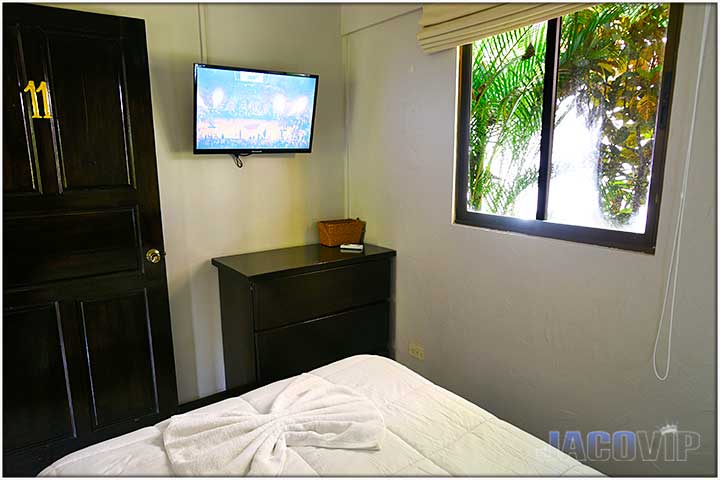 Corner view of bed with window and tv