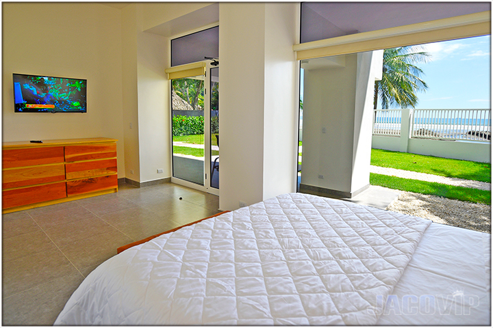 large bedroom with queen size bed and beach views