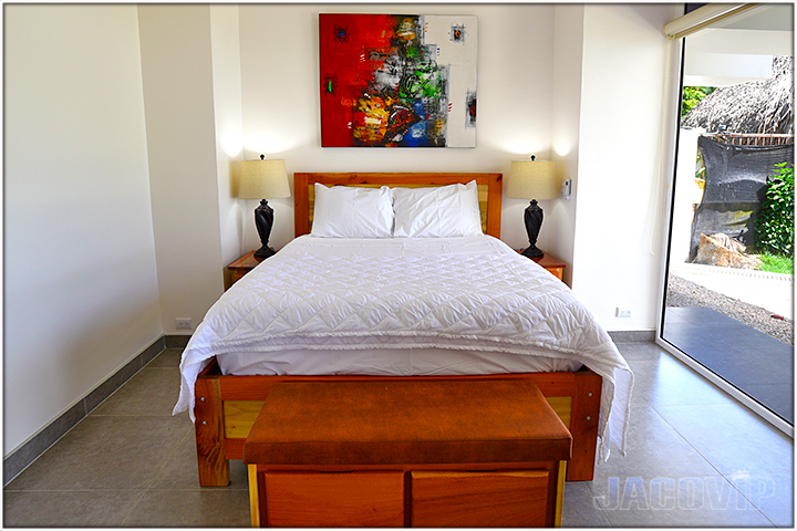 queen bed with white duvet and red modern artwork