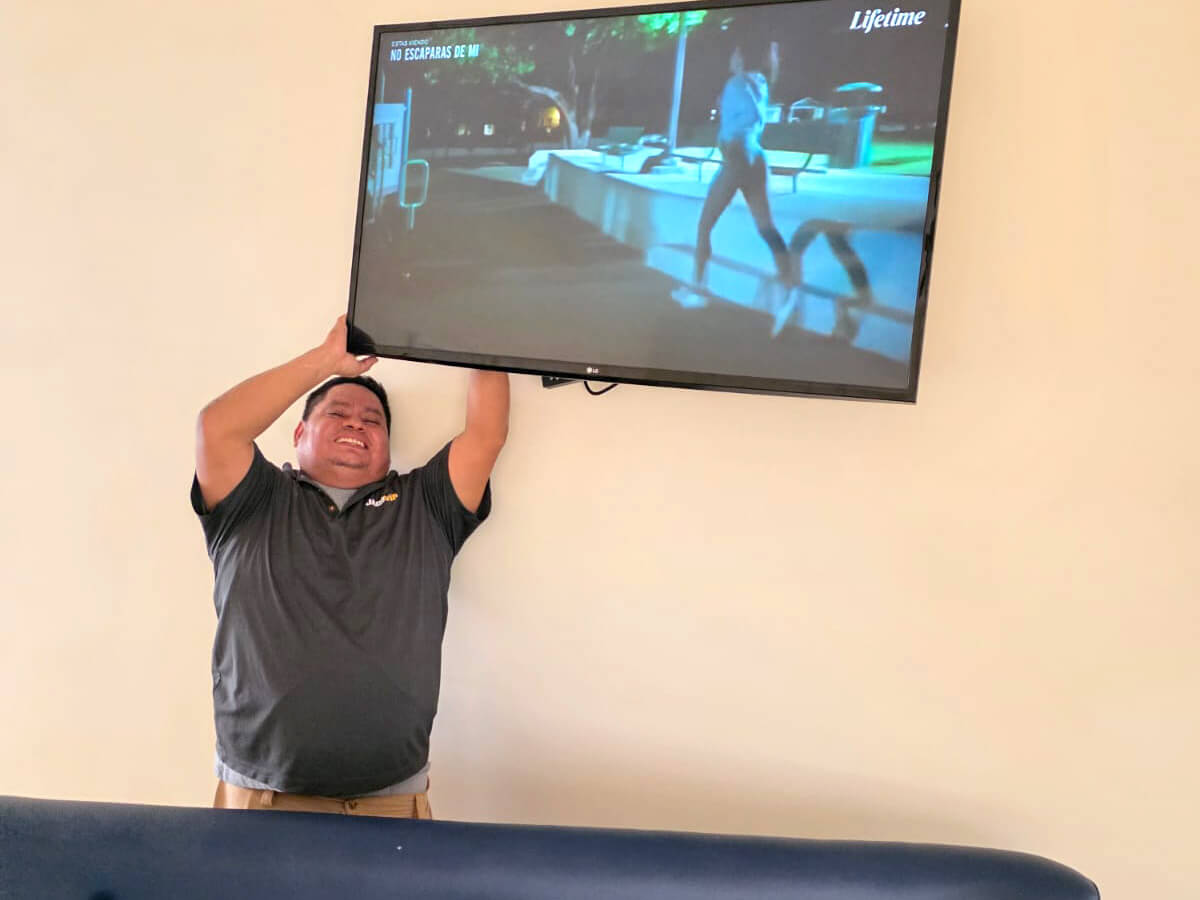 JacoVIP maintenance staff installing a TV wall mount at a vacation rental home in Costa Rica