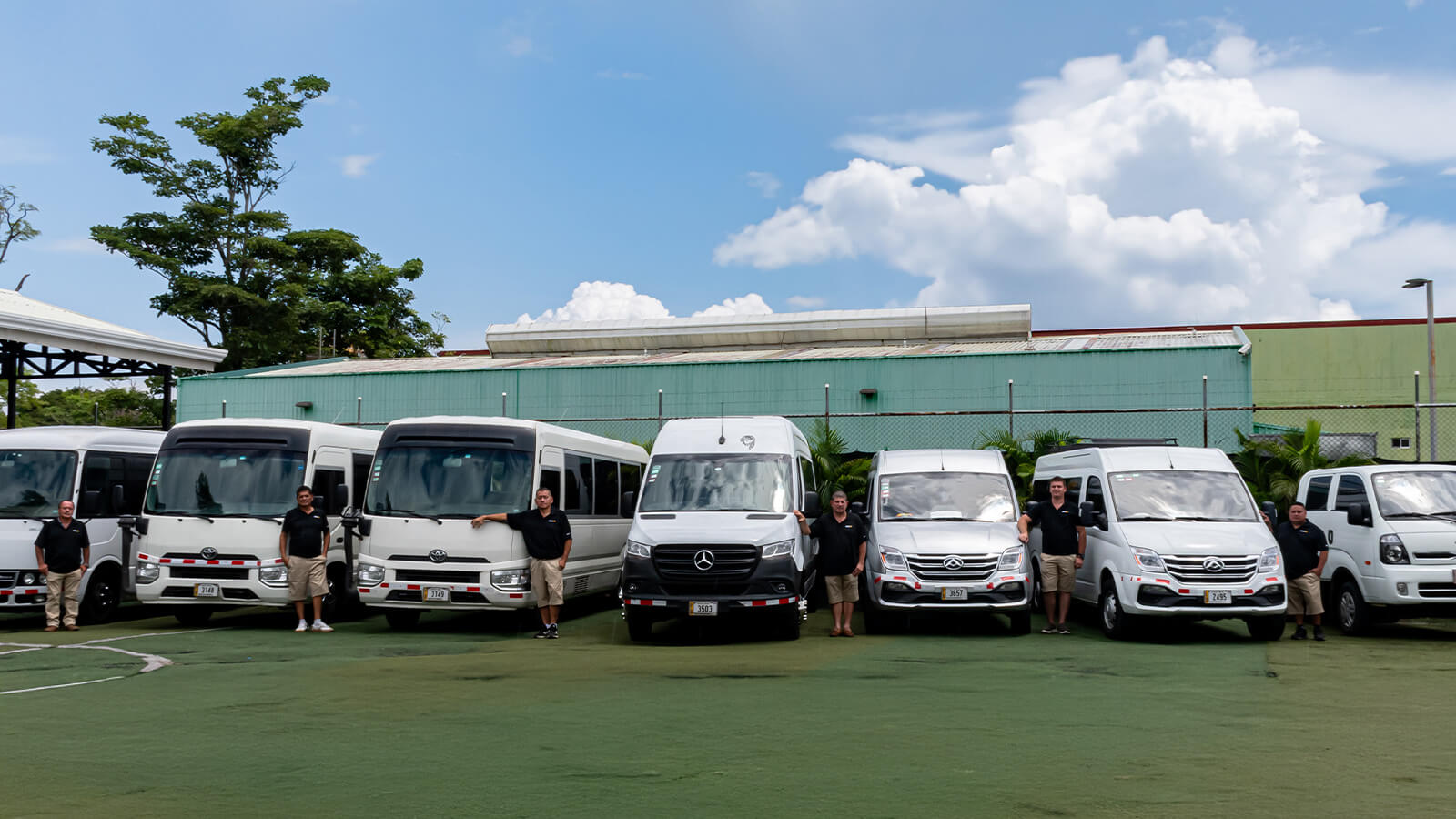 JacoVIP shuttle drivers standing beside branded minibuses outside headquarters