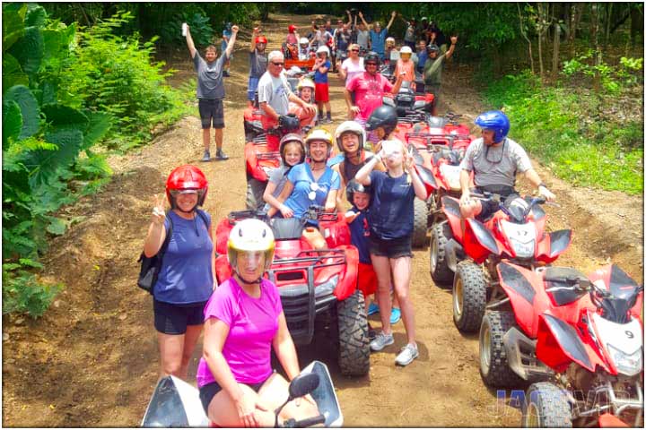 Large group stopped on dirt trail during ATV tour