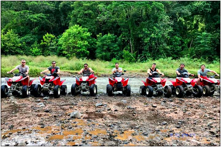 Line of ATVs on muddy shore of Tulin river