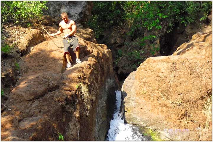 Getting ready to jump of waterfall into natural pool below