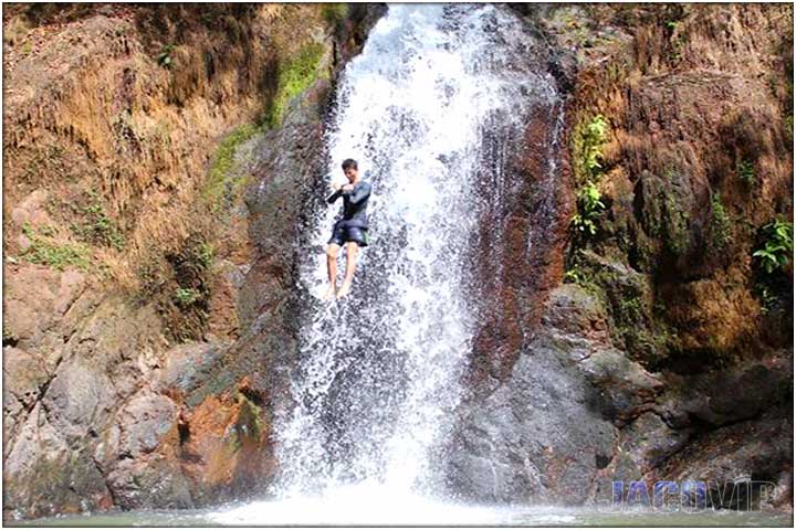 Jumping of cliff over waterfall