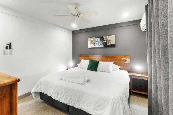 White duvet on bed contrasting with dark grey wall behind bed