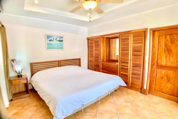 1 King Size Bed Bedroom 2 at Casa Cuatro vacation rental with wood headboard, closets, and king bed