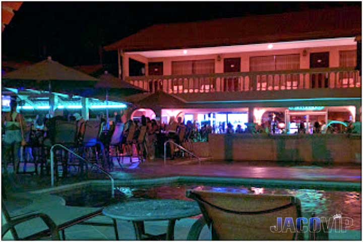 Night time view of pool bar from other side of pool