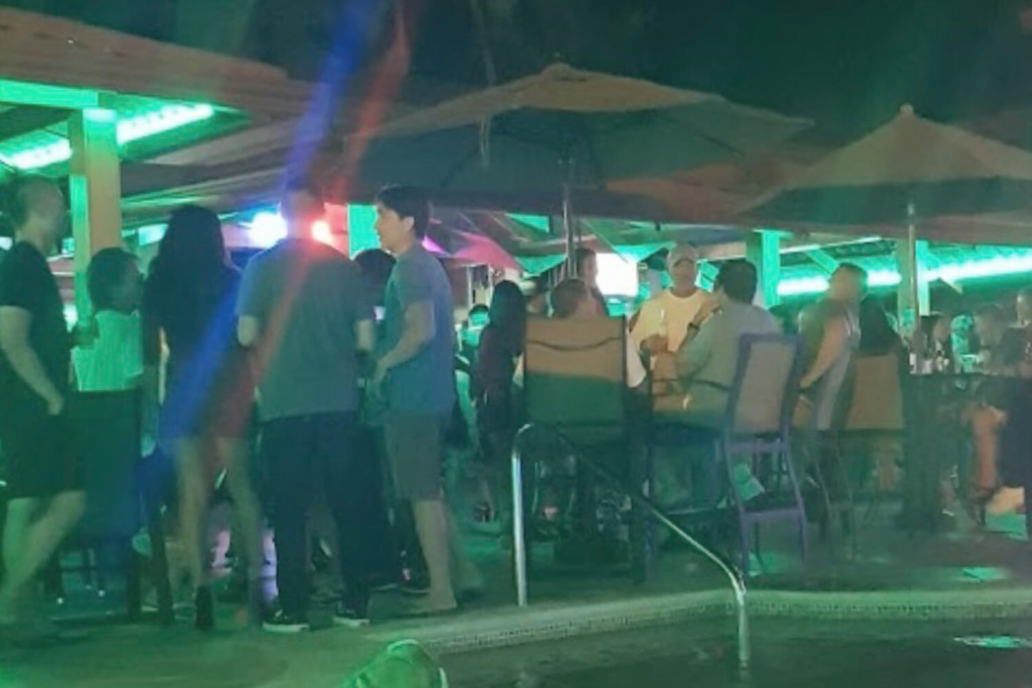 Busy pool bar with men and women enjoying nightlife at Hotel Cocal, Jaco Costa Rica