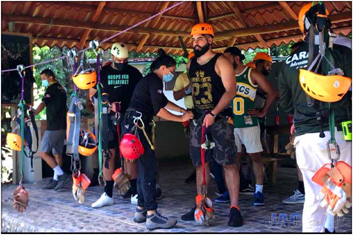 Tour guides helping guests put on equipment for zip line tour