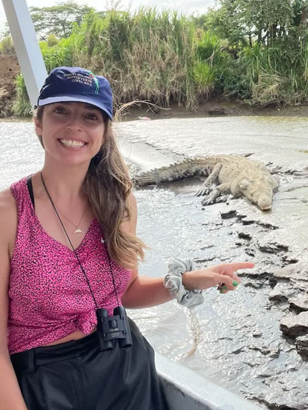 Woman pointing at American crocodile on the Tarcoles River boat tour near Jaco Costa Rica