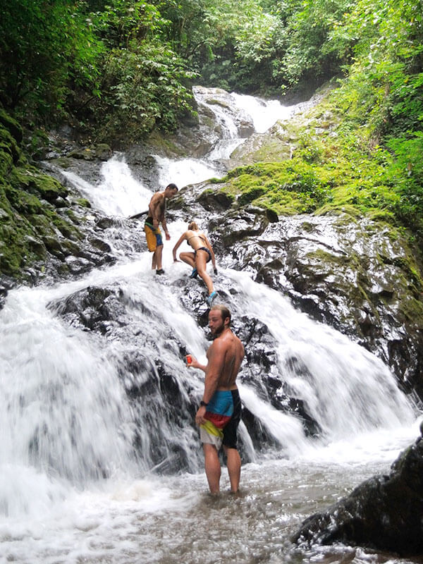 Group climbing and swimming on multi-tiered jungle waterfall on Explorer tour near Jaco Costa Rica