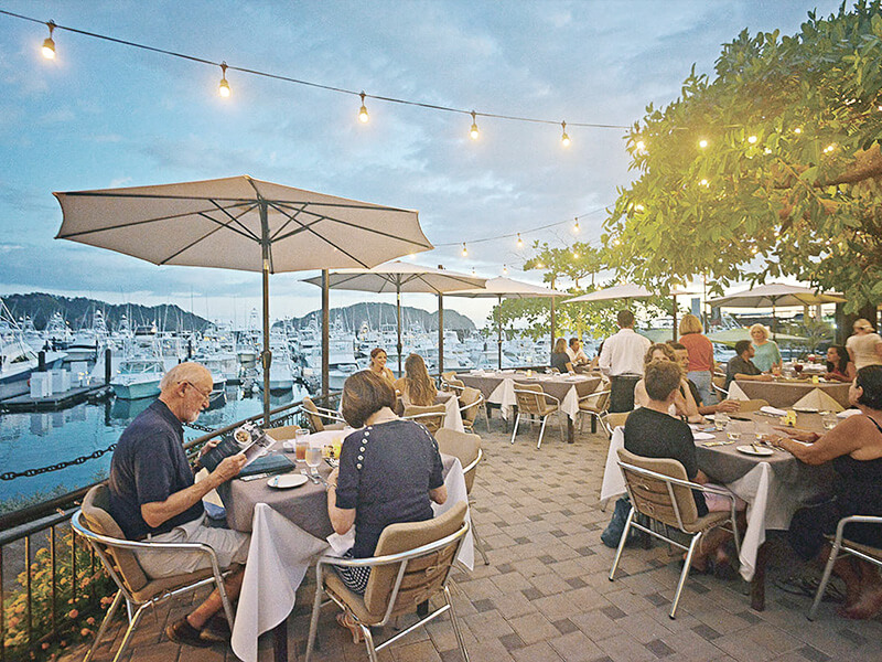 Outdoor dining at Los Sueños Marina restaurant with string lights and boats in background Costa Rica