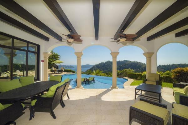 Outdoor living and dining area with ocean view at Casa Puesta Del Sol