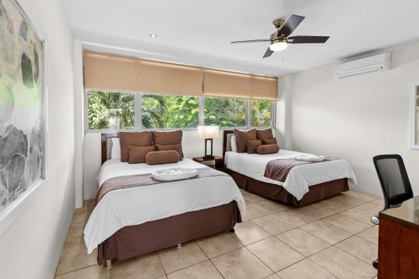 Welcoming two queen bedroom 10 with mounted TV ceiling fan and en-suite at this Costa Rica vacation villa in Jaco