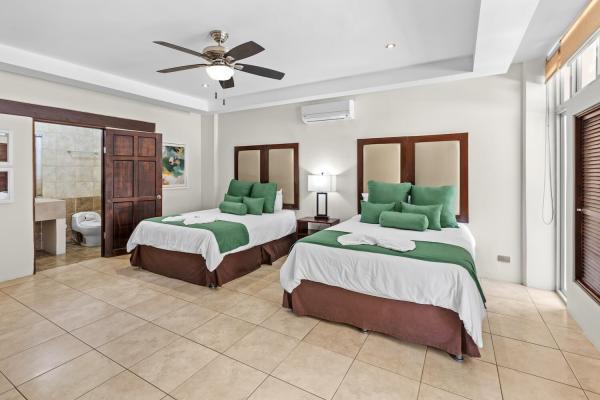 Cozy two queen bedroom 6 with ceiling fan tile floors and bedside lamps at this Costa Rica vacation villa near Jaco