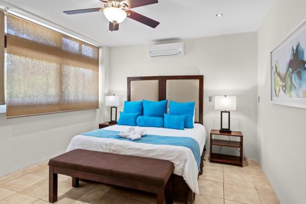 King bedroom 14 with bold pillow accents wall art ceiling fan and en-suite at this large multi-suite vacation home
