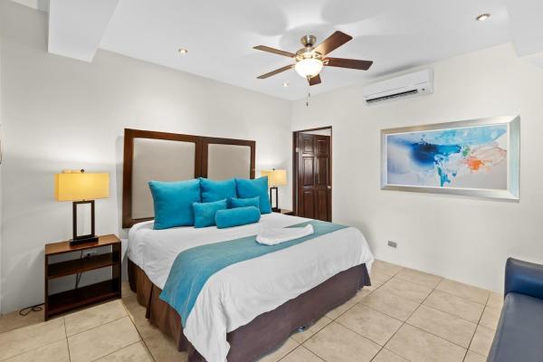 Bright king bedroom 17 with bold color accent pillows tropical decor and ceiling fan at this Jaco Beach family rental