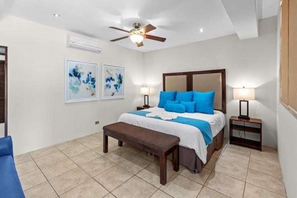 Airy king bedroom 18 with bedside lamps natural decor and en-suite at this welcoming family vacation home near Jaco
