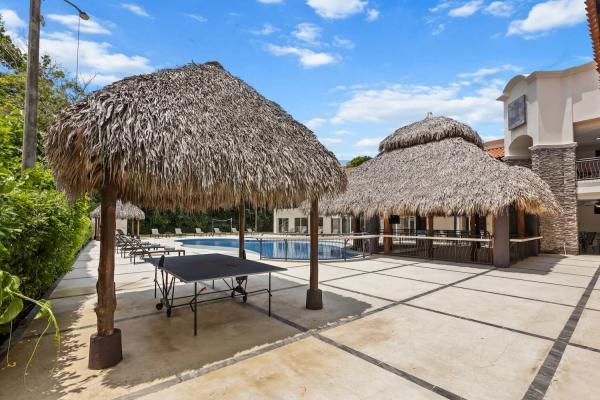 Covered palapa with ping pong table additional palapa structures and palms surrounding the paved game area outside