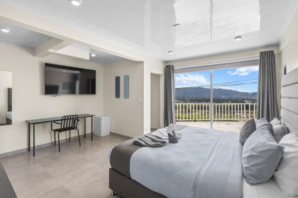 1 King Size Bed Large bedroom with king bed, desk and tv at Jaco Sky House vacation rental villa