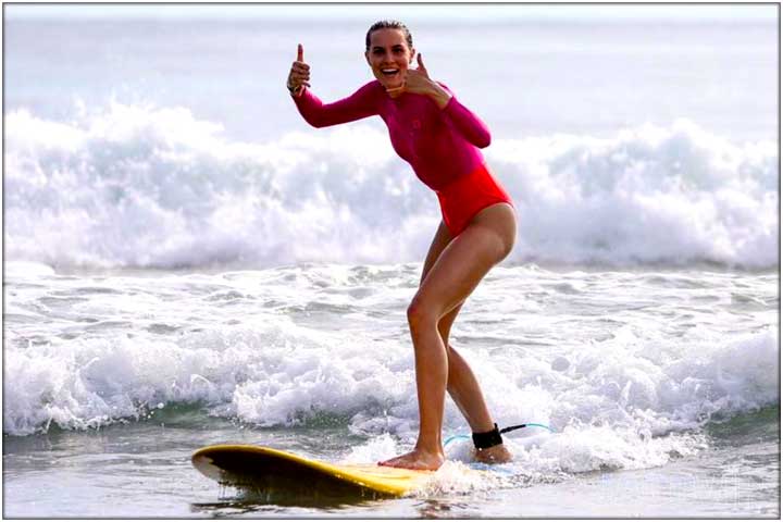 Girl in red swimsuit learning to surf in Jaco