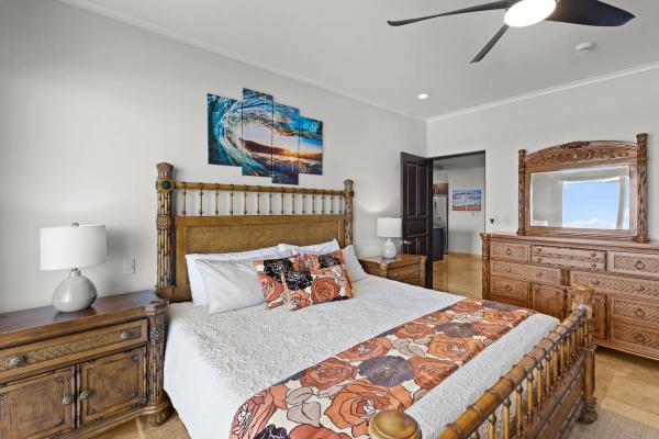 Master bedroom with carved wood king bed, dresser and mirror at The Palms 1002