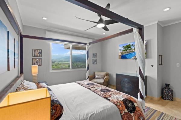 Second bedroom at The Palms 1002 with canopy bed and window view of the Jaco hills