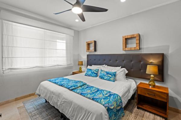Third bedroom at The Palms 1002 with upholstered headboard and blue bedding