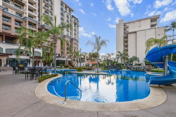 Resort pool with waterslide beside The Palms condominiums in Jaco Beach