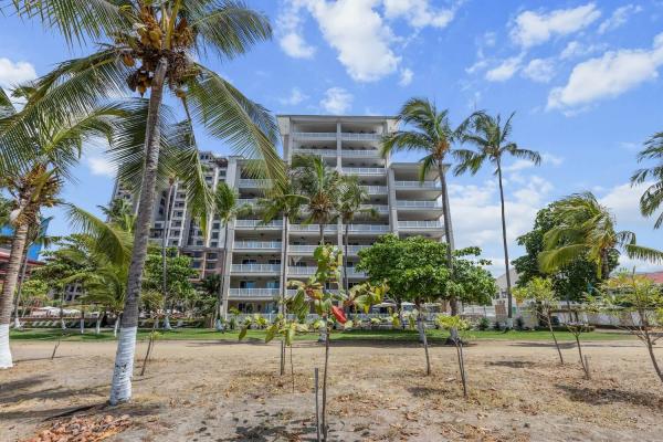 The Palms beachfront condominium tower in Jaco Beach seen from the sand with palm trees