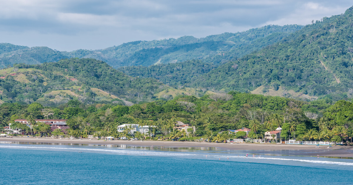 Lush green mountains of the Green Coast rising behind Jaco Beach, Costa Rica
