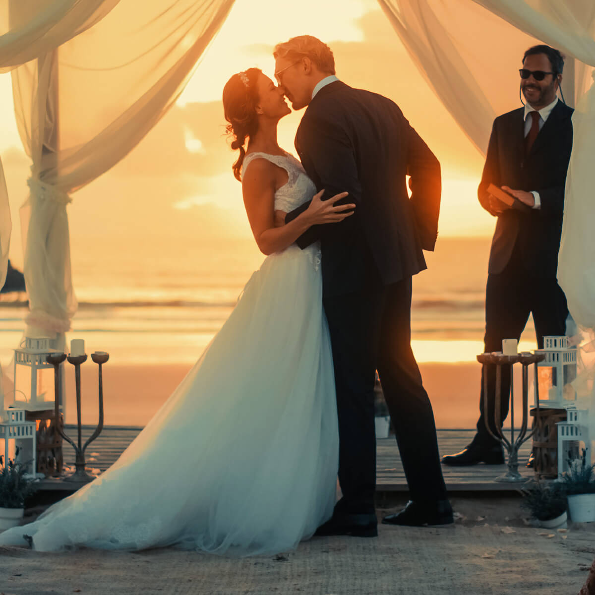 Destination wedding in Costa Rica with a couple kissing at the beachfront alter.