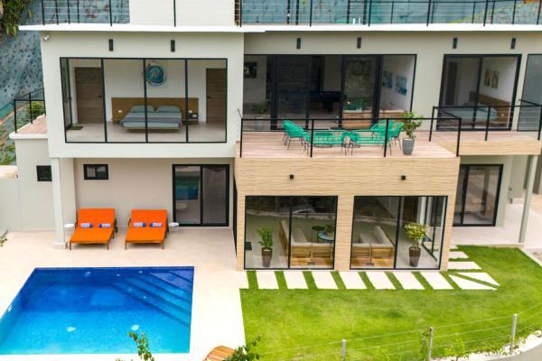 Aerial view of the house facade, second floor deck and pool