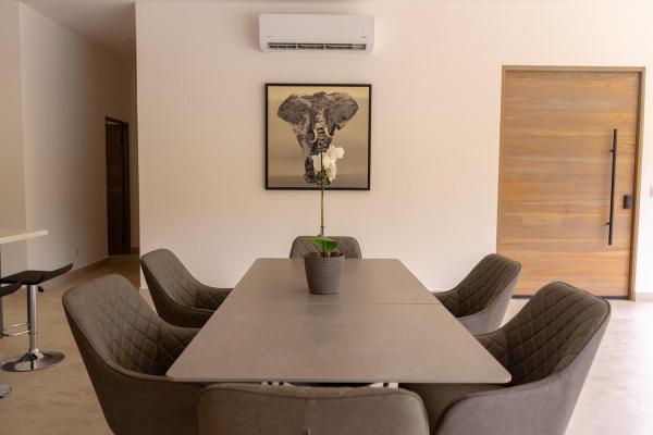 Dining table with upholstered chairs and elephant artwork