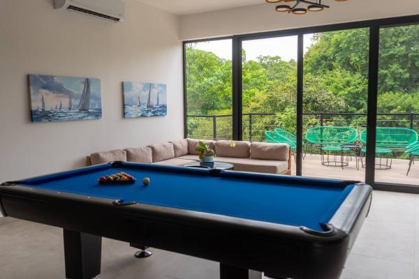 Upstairs lounge with pool table, sofa and doors to the deck
