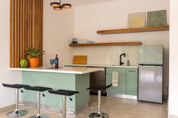 Upstairs mini kitchen and bar with stools and fridge