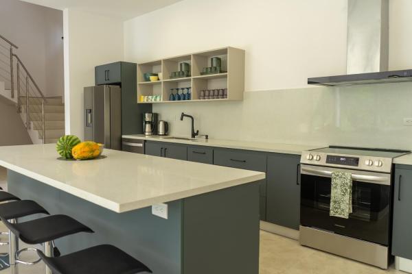 Kitchen with large island, bar stools and stainless steel appliances