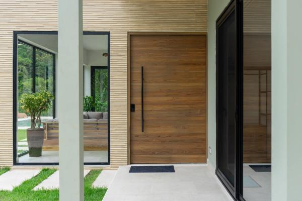 Front entrance with tall wooden door and glass walls