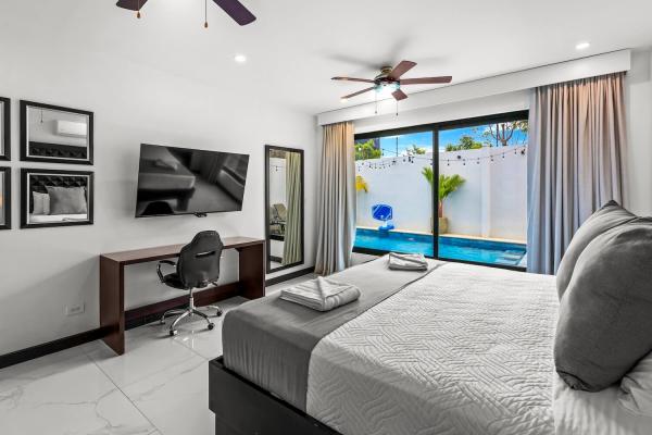 Spacious king bedroom with designer modern decor, built-in closet, and large tile floors in Costa Rica