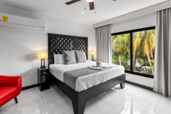 1 King Bed Elegant king bedroom with upholstered headboard, mirrored closet doors, and terrace access at Villa Norma
