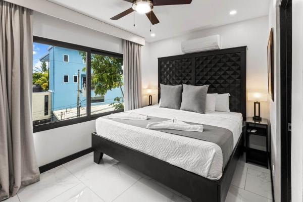 1 King Bed Spacious king bedroom with tufted headboard, large bright window, and ensuite bathroom at this Jaco vacation rental